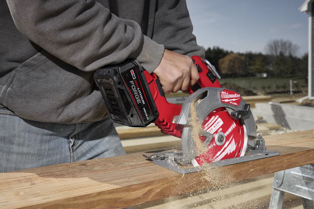 Man using saw with Milwaukee redlithium forge battery