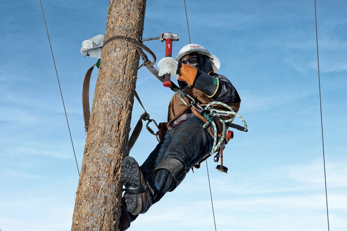 Lineman tethered to a post using Milwaukee Lineman Tools